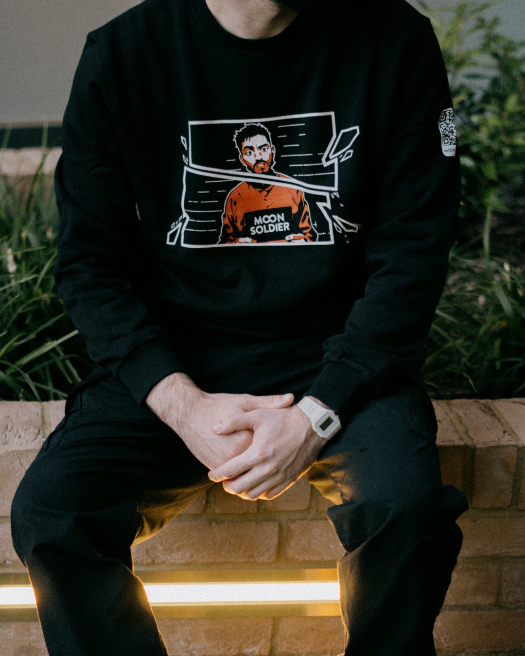 Moon Soldier Vigilante black sweatshirt with vigilante character graphic in a fragmented frame, worn by model in a casual setting.