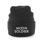 Black knit beanie featuring the Moon Soldier logo in white, styled for casual and cozy wear.