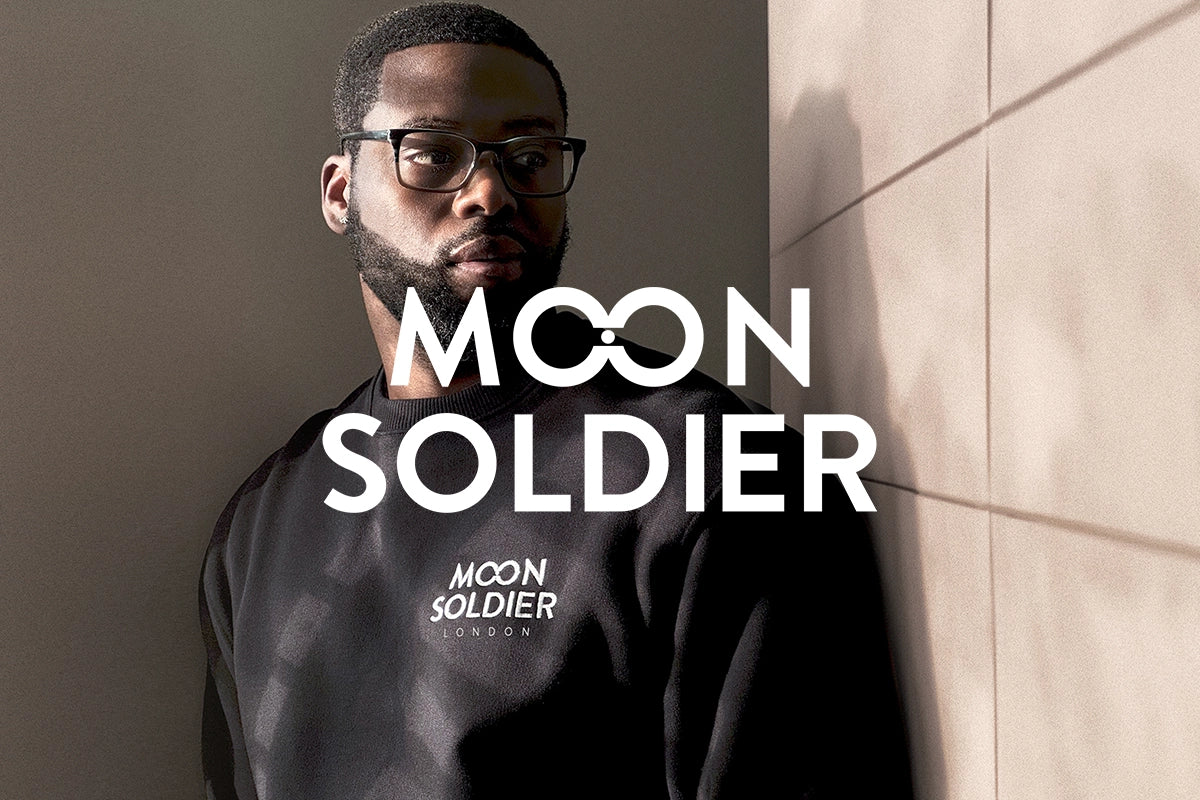 Moon Soldier London branding on a black soft cotton crewneck sweatshirt, modeled with a modern and minimalistic background for promotional visuals.